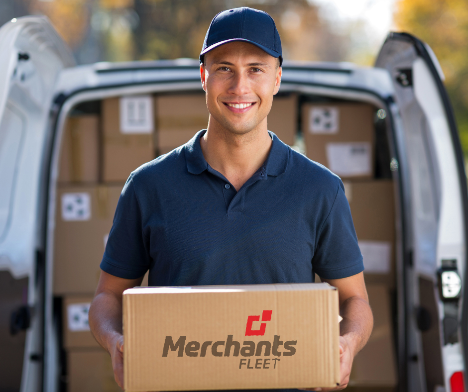 Delivery person in a blue cap holds a cardboard box with "Merchants Fleet" on it, standing by an open van full of boxes.