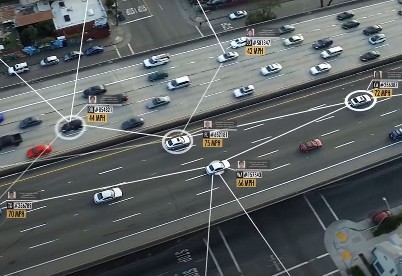 Aerial view of a highway with cars tracked by digital tags showing speed and other data.